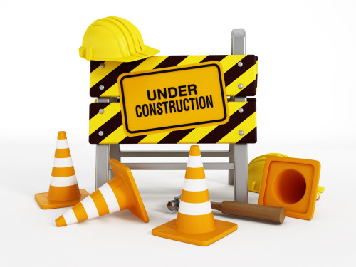 Under construction sign, helmets, traffic cones and tools.